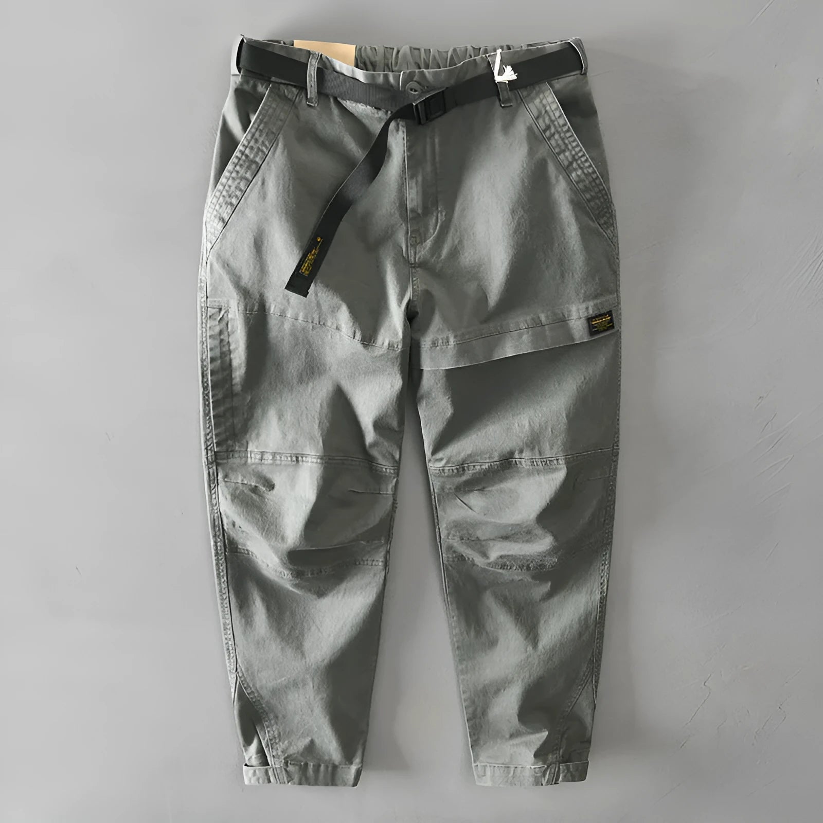 Men's khaki coloured loose-fit casual overalls with an elastic waistband on a hanger.