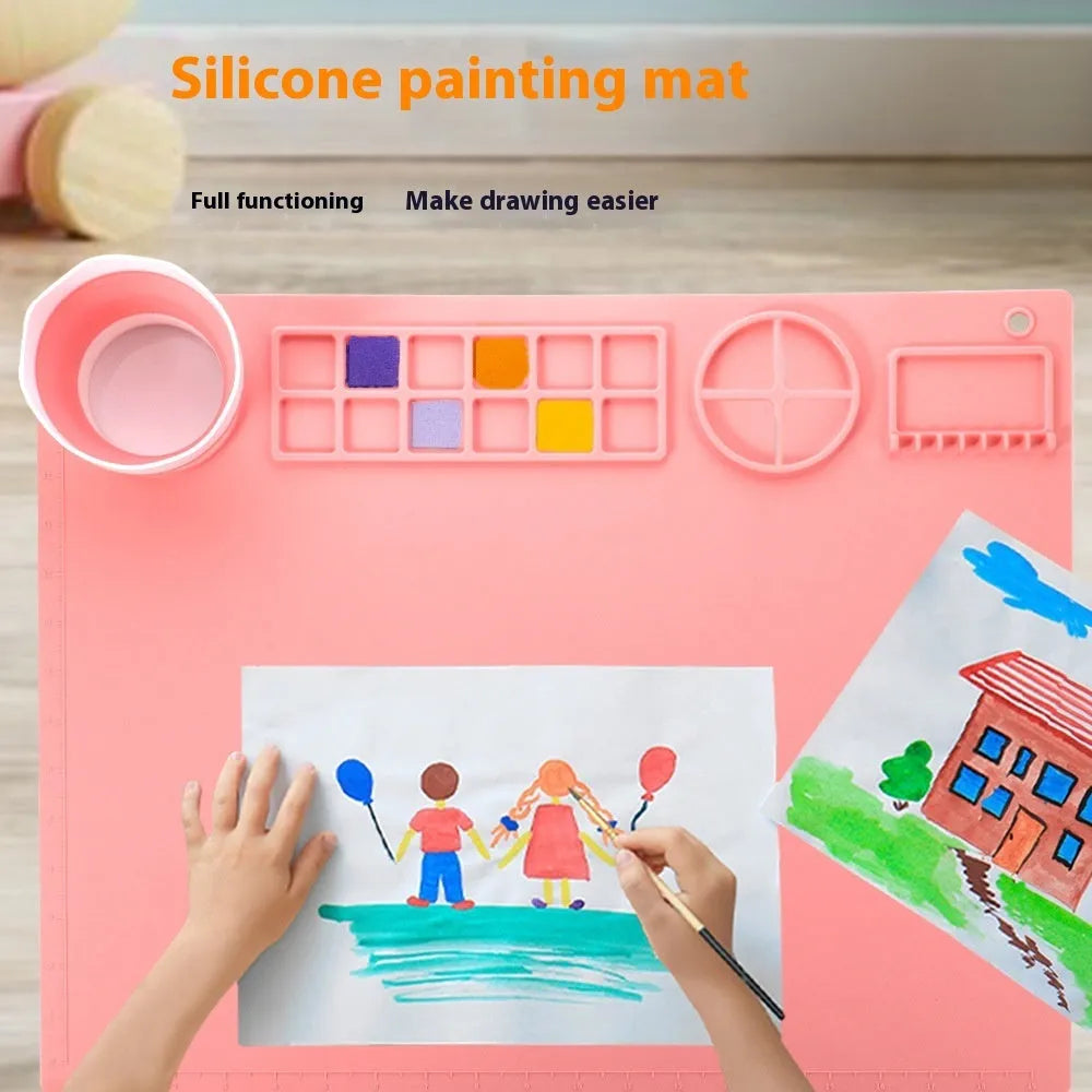 Green silicone painting mat measuring 50 by 40 centimetres with two round bowl wells for holding water or paint.