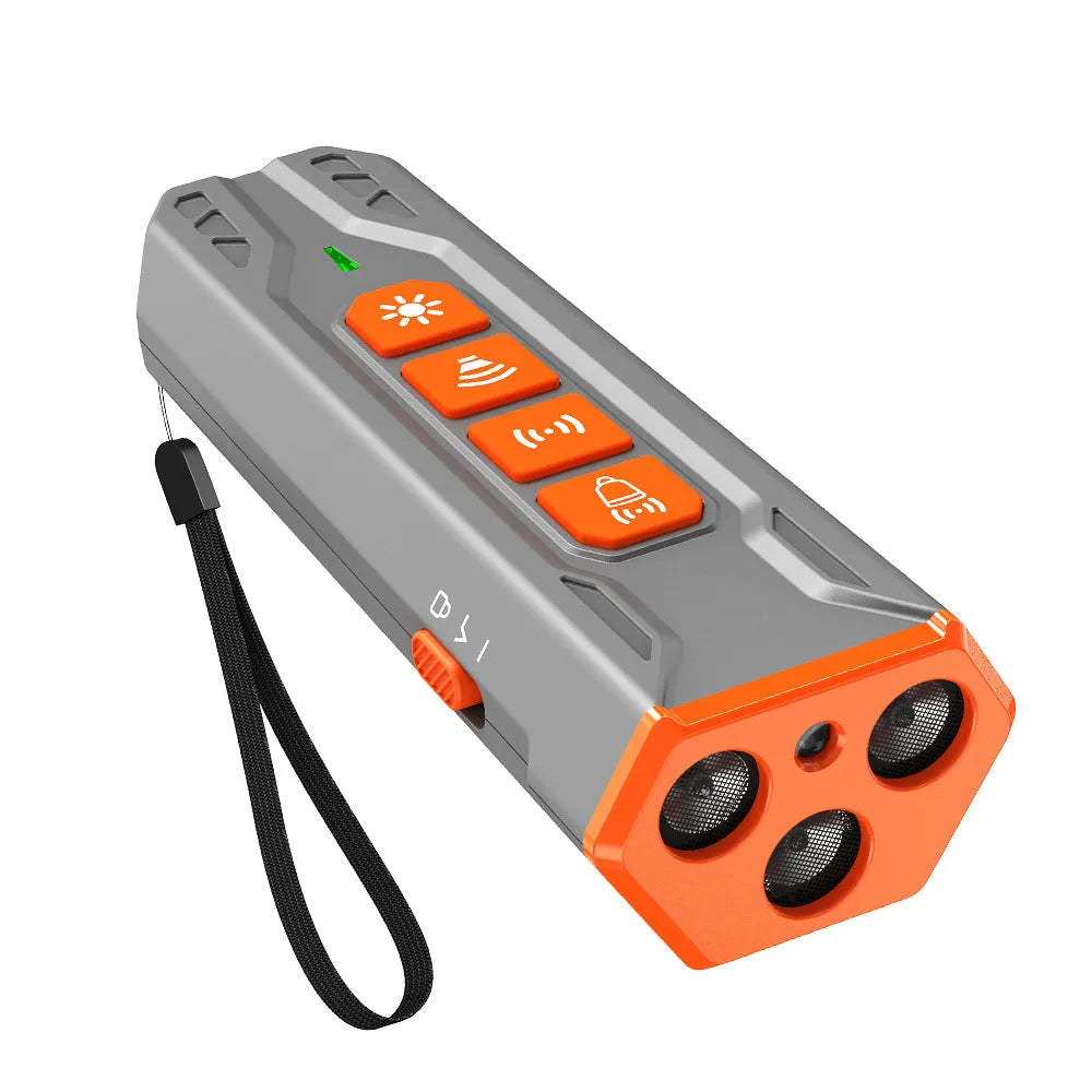 Grey and orange coloured three-head ultrasonic dog trainer with remote control on a table.