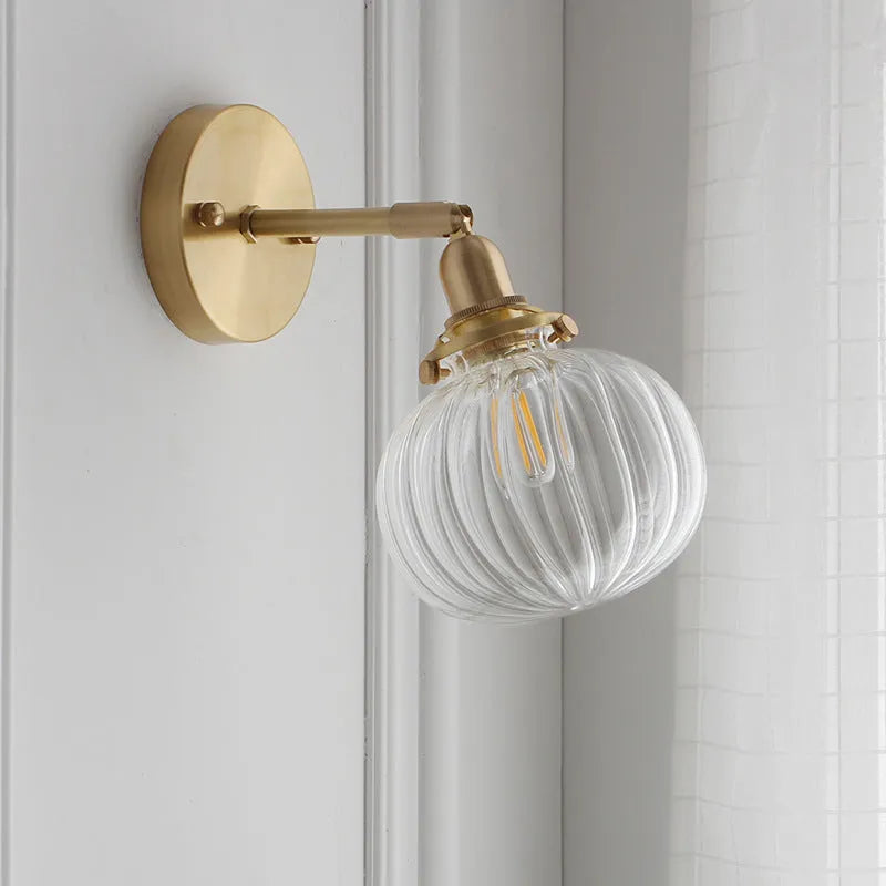 Pumpkin-shaped transparent glass wall lamp mounted on a wall