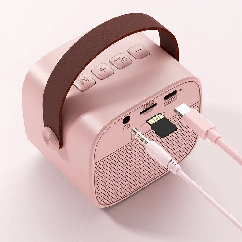 Small white portable Bluetooth speaker with a built-in microphone on a table.