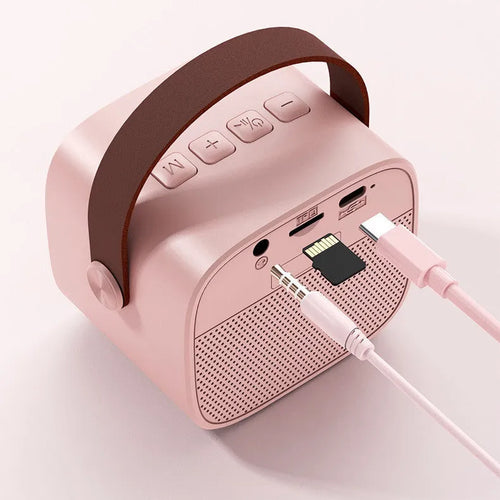 Small white portable Bluetooth speaker with a built-in microphone on a table.