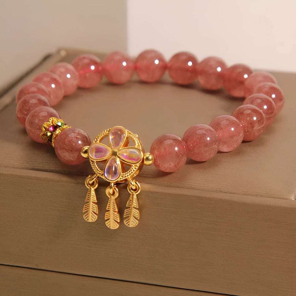 Women's bracelet with strawberry quartz beads and crystal accents featuring four-leaf dream catcher pendant