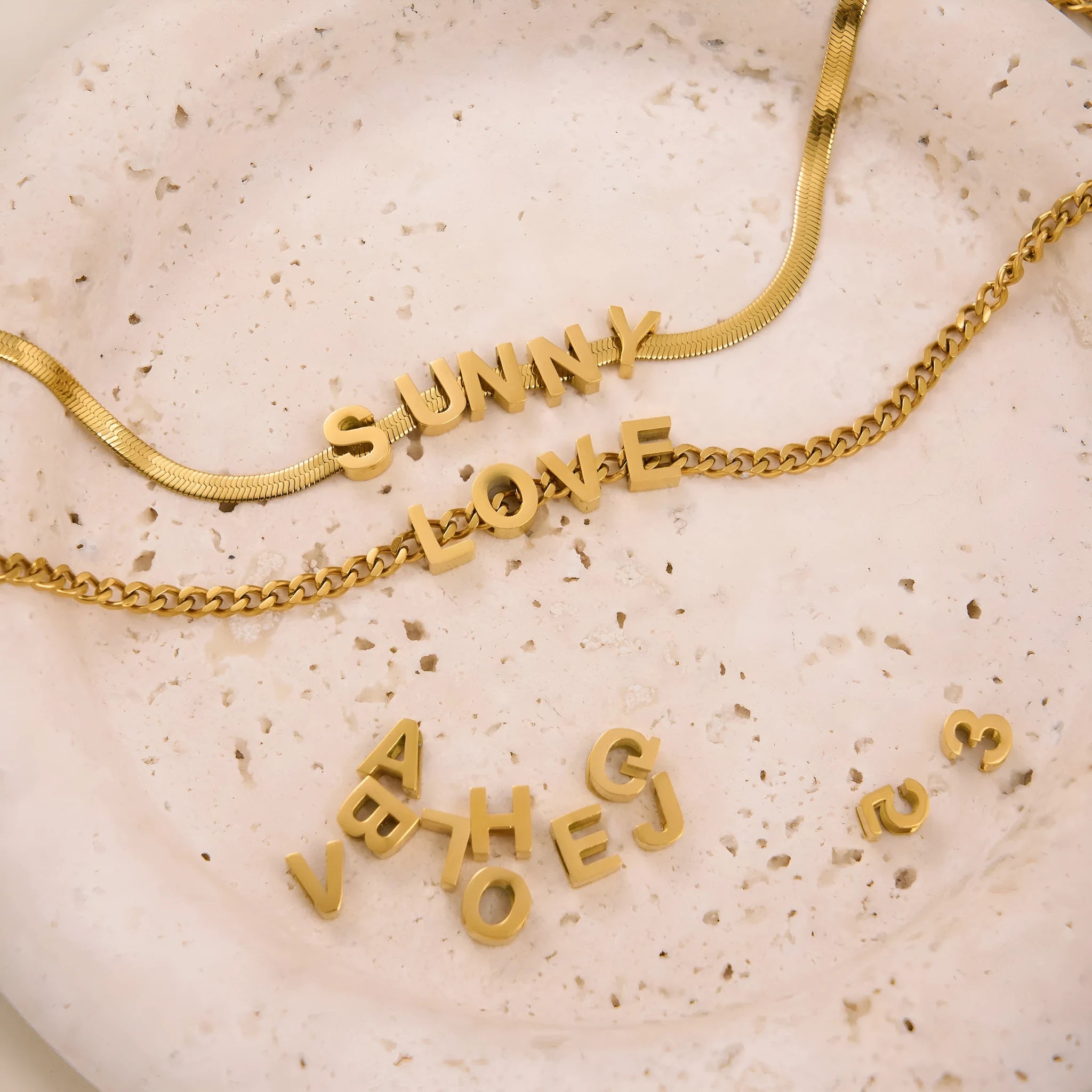 Gold or silver titanium steel necklace with a personalised letter, number, or heart pendant on a 40.5cm chain.