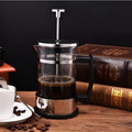 Compact 350ml manual pour-over coffee maker with glass carafe and stainless steel filter.