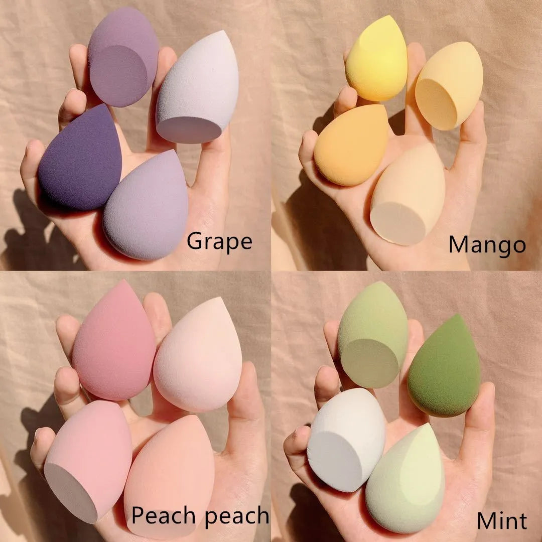 Cube-shaped plastic makeup sponge storage case containing four coloured synthetic beauty egg sponges.