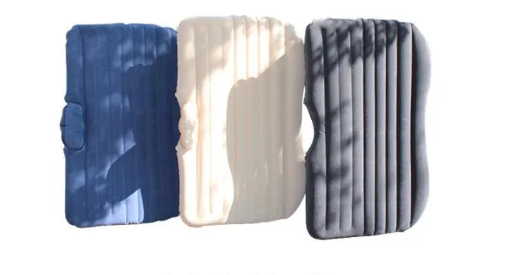 Inflatable car bed with flocked surface and two pillows, shown folded next to its storage bag.