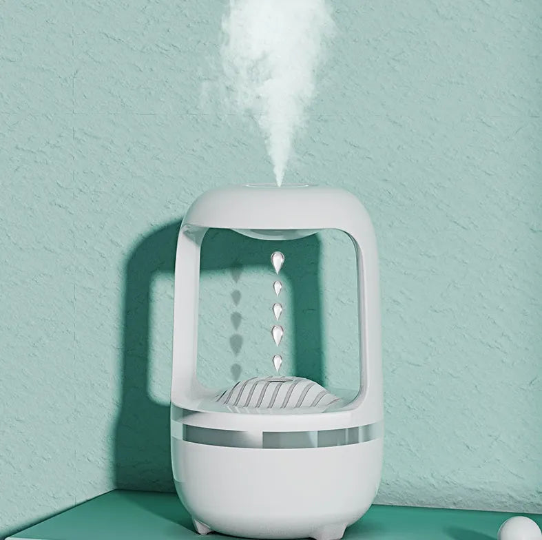 White anti-gravity humidifier with water droplet effect on a desk next to a USB cable.