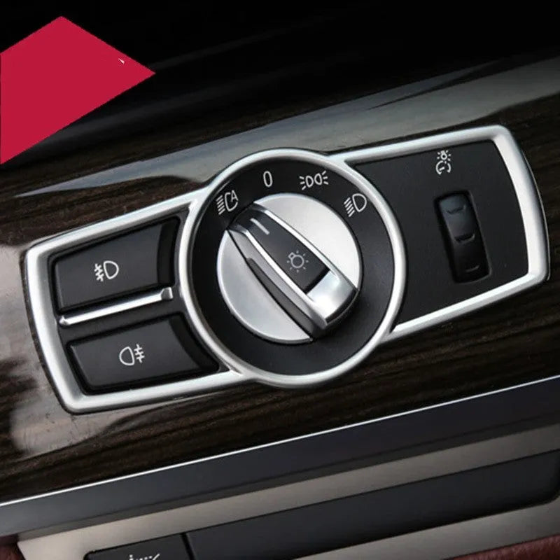 Silver ABS plastic decorative interior sticker for BMW 5 Series headlight switch frame.