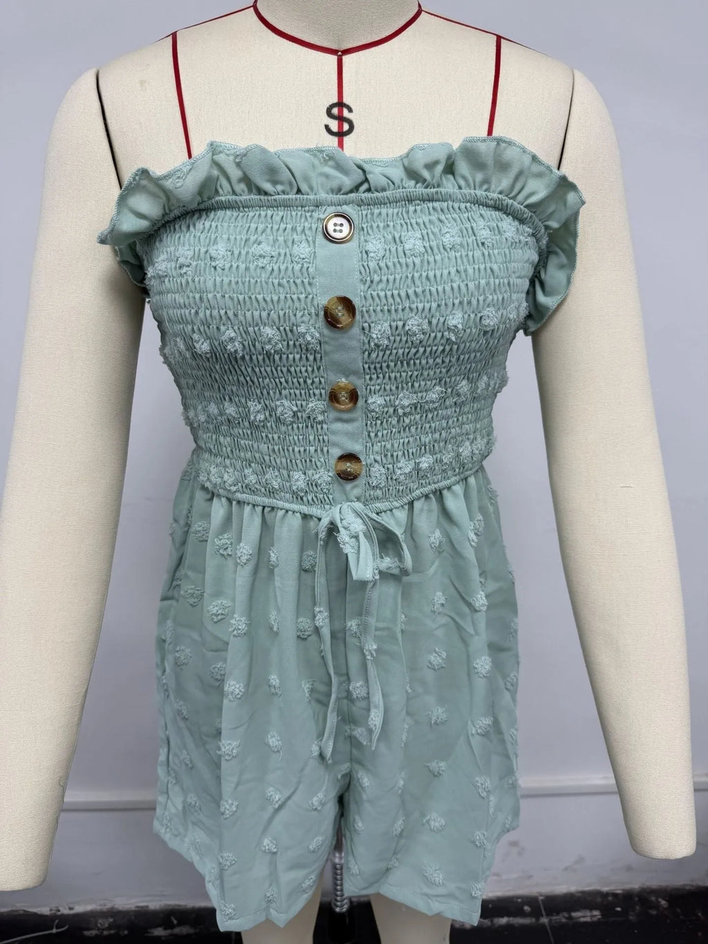 Women's sleeveless off-shoulder jumpsuit in solid colour with elastic waist and button details