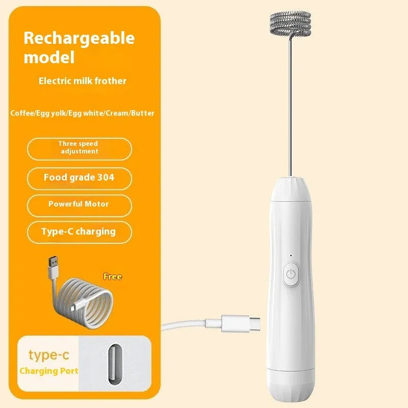 Compact black handheld USB rechargeable milk frother with stainless steel whisk on a kitchen counter.