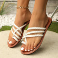 Women's white clip-toe woven flat sandals with a rubber sole on a neutral background.