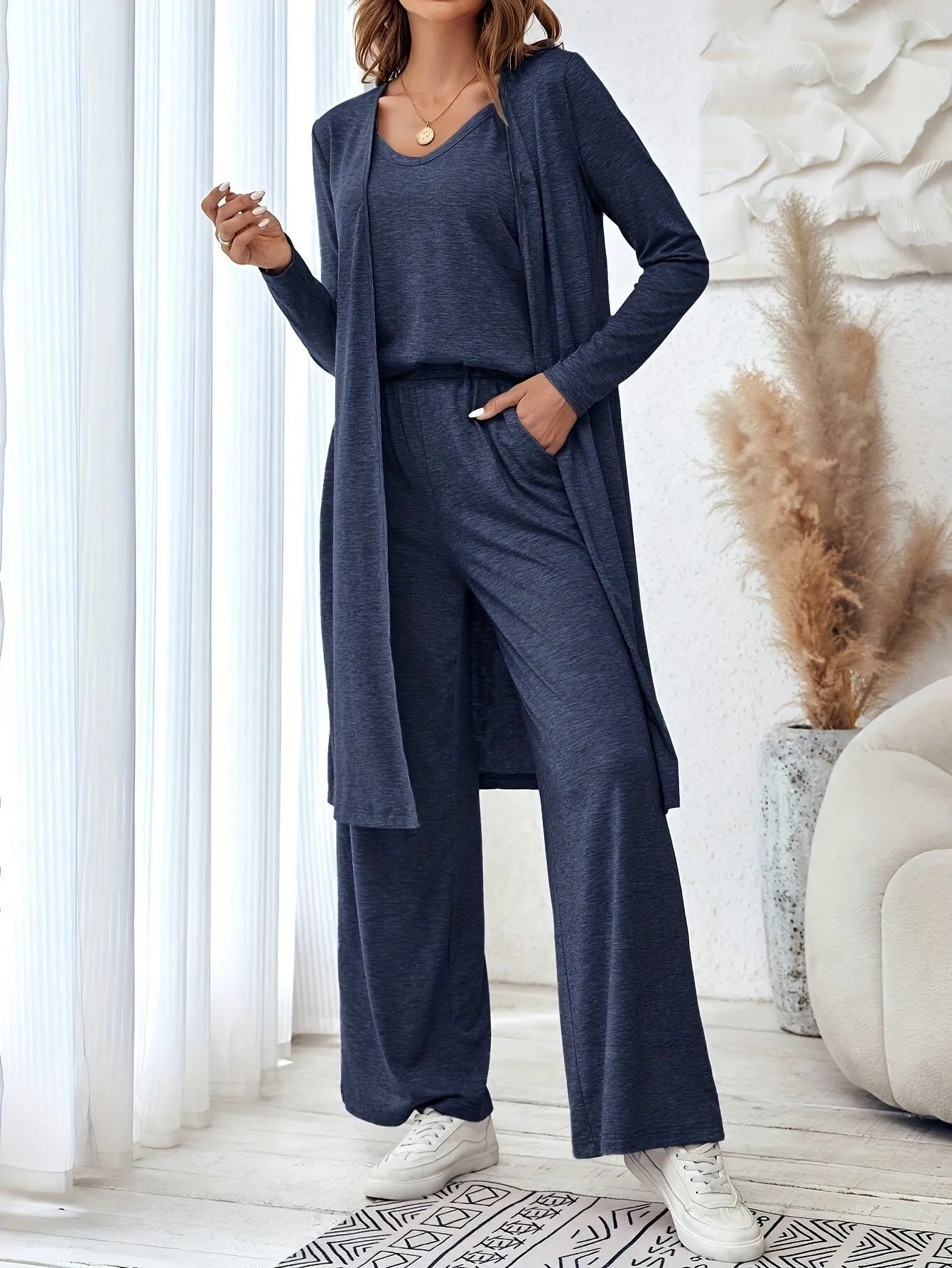 Blue women's casual suit set with cardigan, long trousers, and suspenders on a hanger.