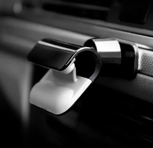 Black gravity car phone holder showing 360-degree rotation on a car dashboard