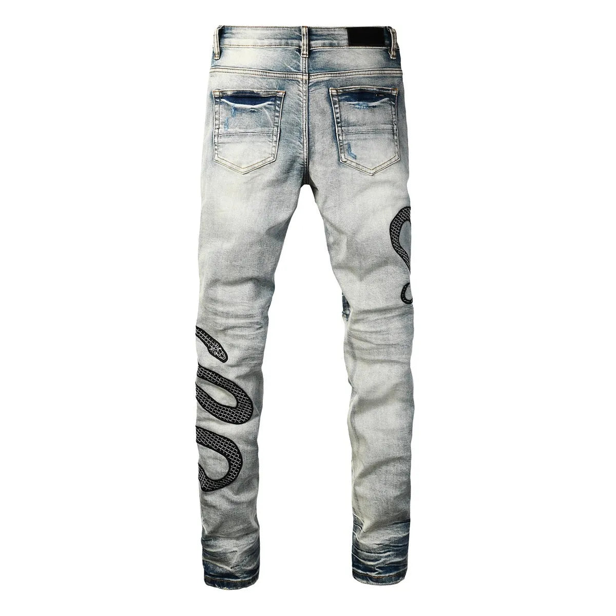 Man's blue distressed skinny jeans with a vintage wash, shown on a model, featuring a button fly and a tapered leg.