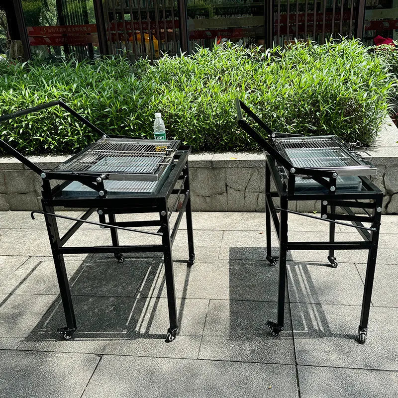 Large foldable charcoal barbecue grill stove shown in outdoor courtyard setting