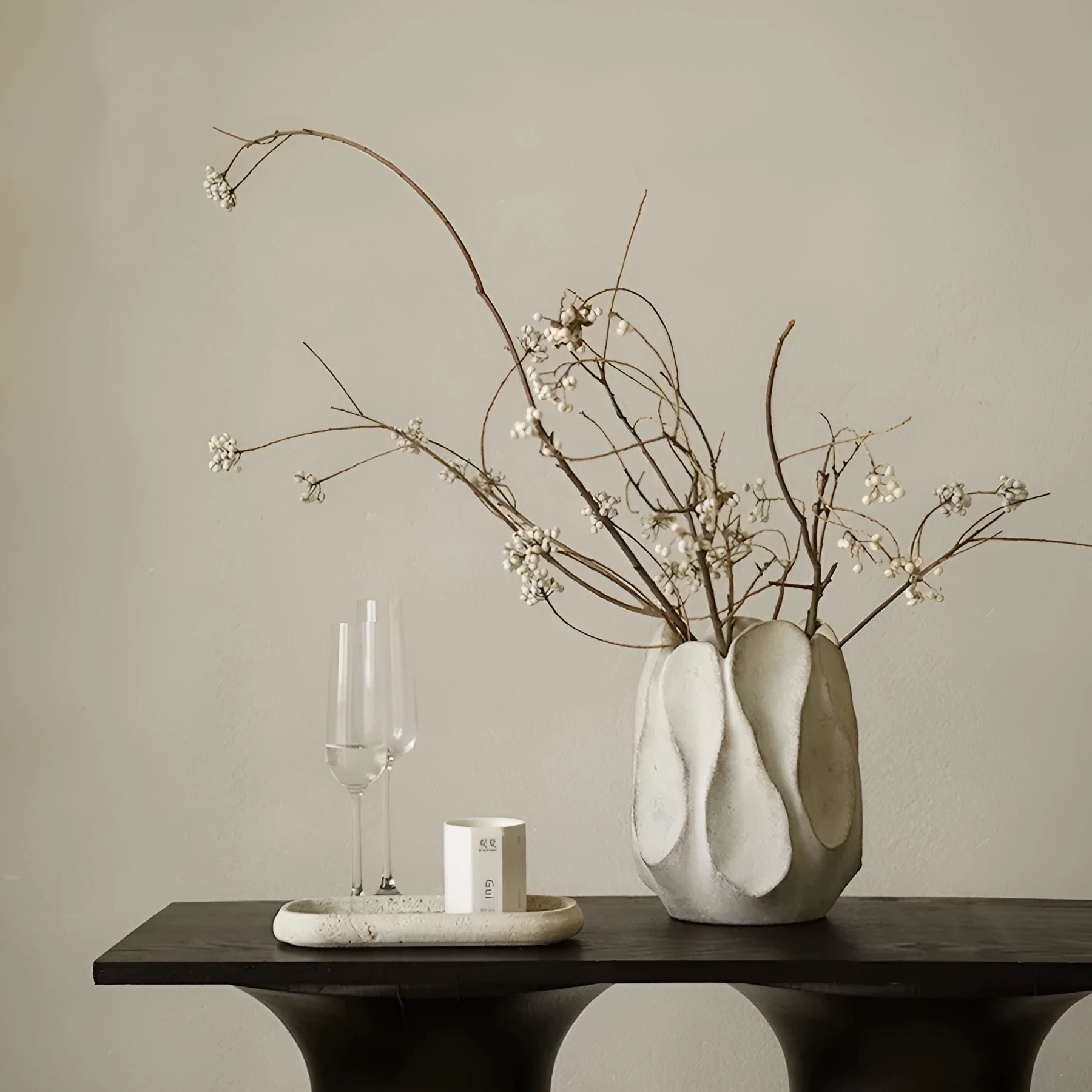 Handmade irregular shaped ceramic vase in natural glaze on a wooden surface.