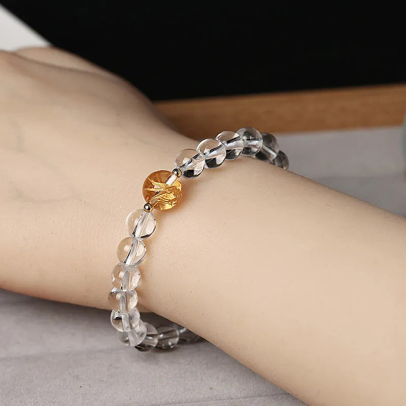 Geometric unisex bracelet with black obsidian agate beads, white crystal beads, and a golden dragon crystal focal bead.