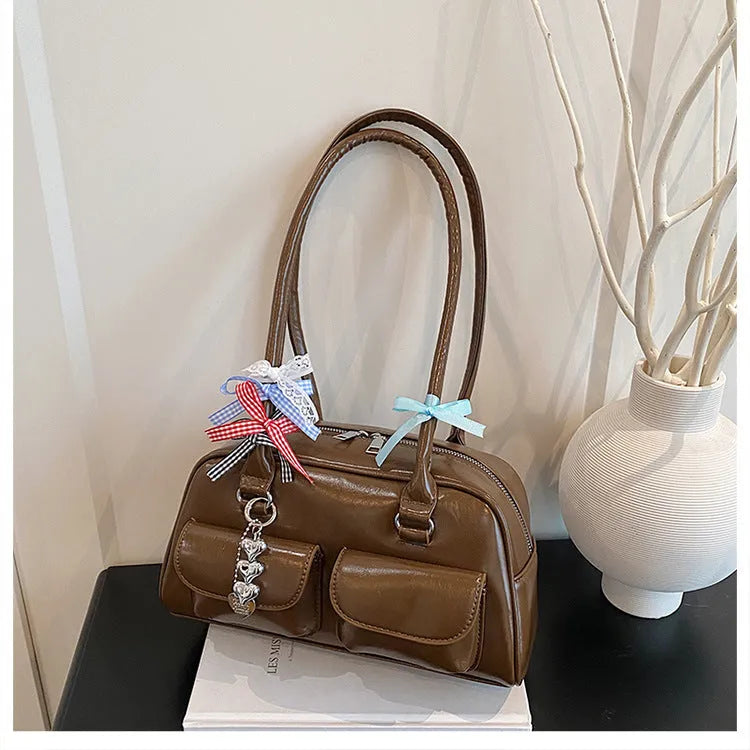 Retro brown PU leather women's pillow handbag with a flap and double shoulder strap on a neutral background.