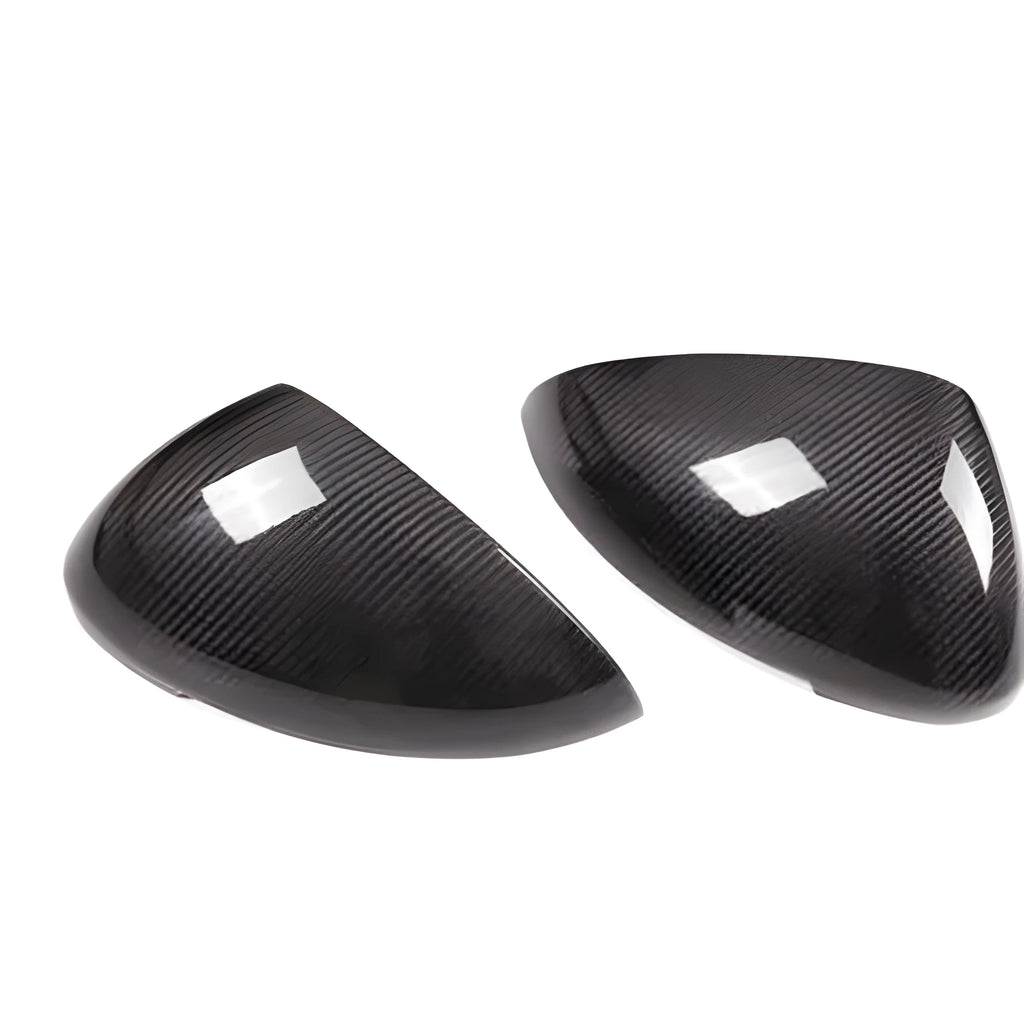 Glossy black true carbon fibre rearview mirror cover for Porsche Macan on a white background