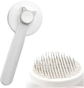 Blue self-cleaning cat and dog brush with rubber handle and retractable pins