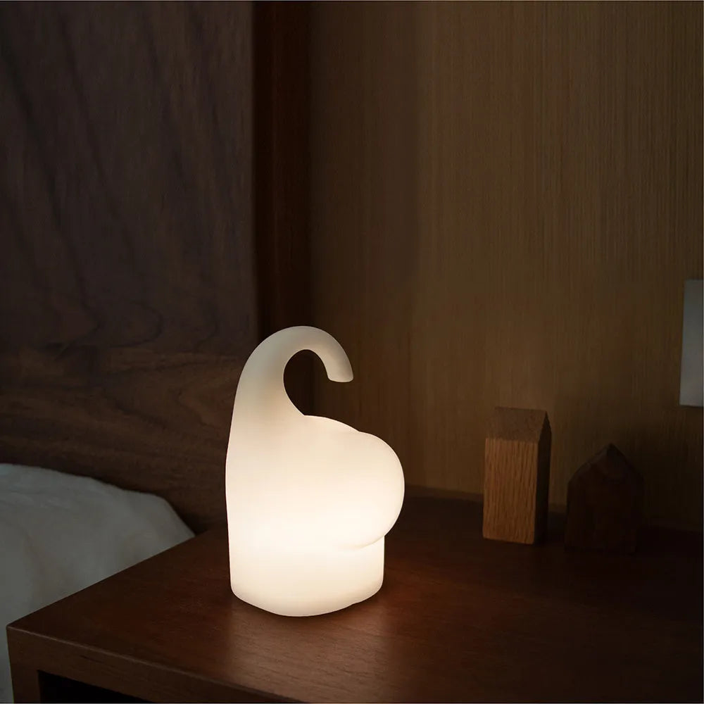 DOMI soft silicone elephant night light on a bedside table emitting warm white glow