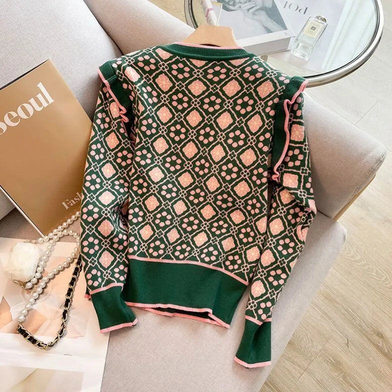 Green loose-fit printed sweater with regular sleeves on a hanger.