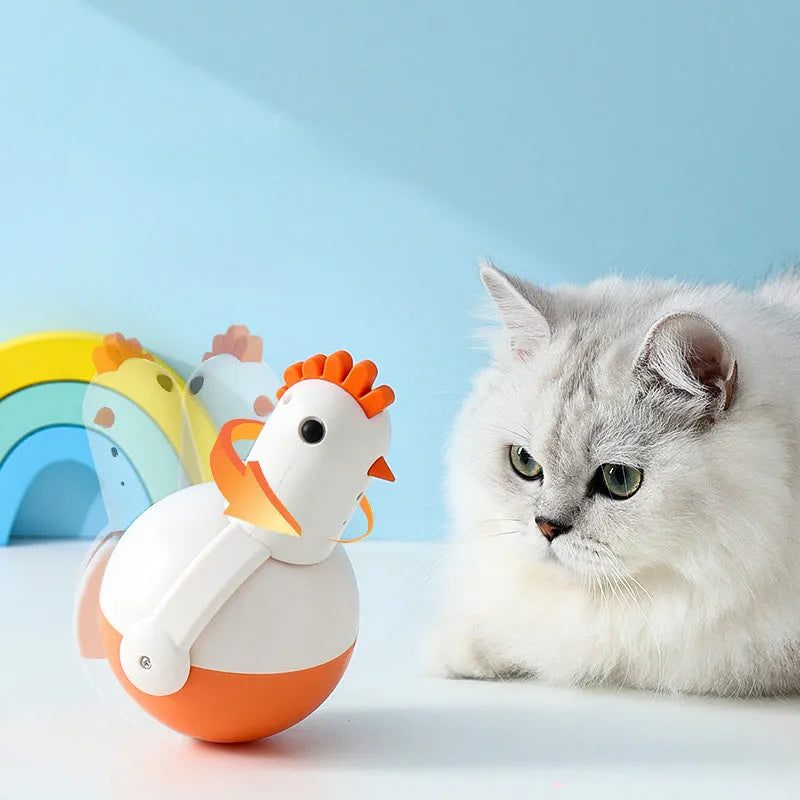 Green or orange electric chicken-shaped cat toy with laser and sound features on a flat surface.