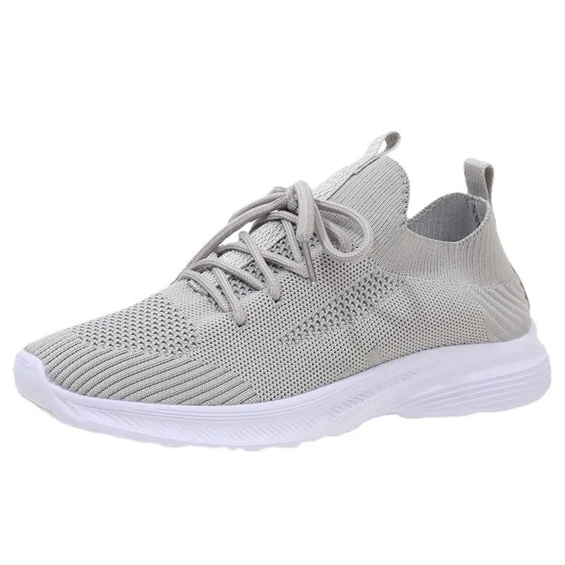 Women's creamy white Flyknit running shoes with mesh lining and low-top design on a rubber sole