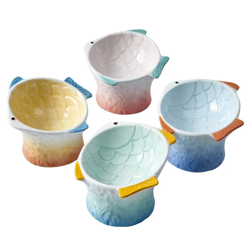 Blue ceramic fish-shaped cat bowl with tilted design and shallow eating surface on a plain background.