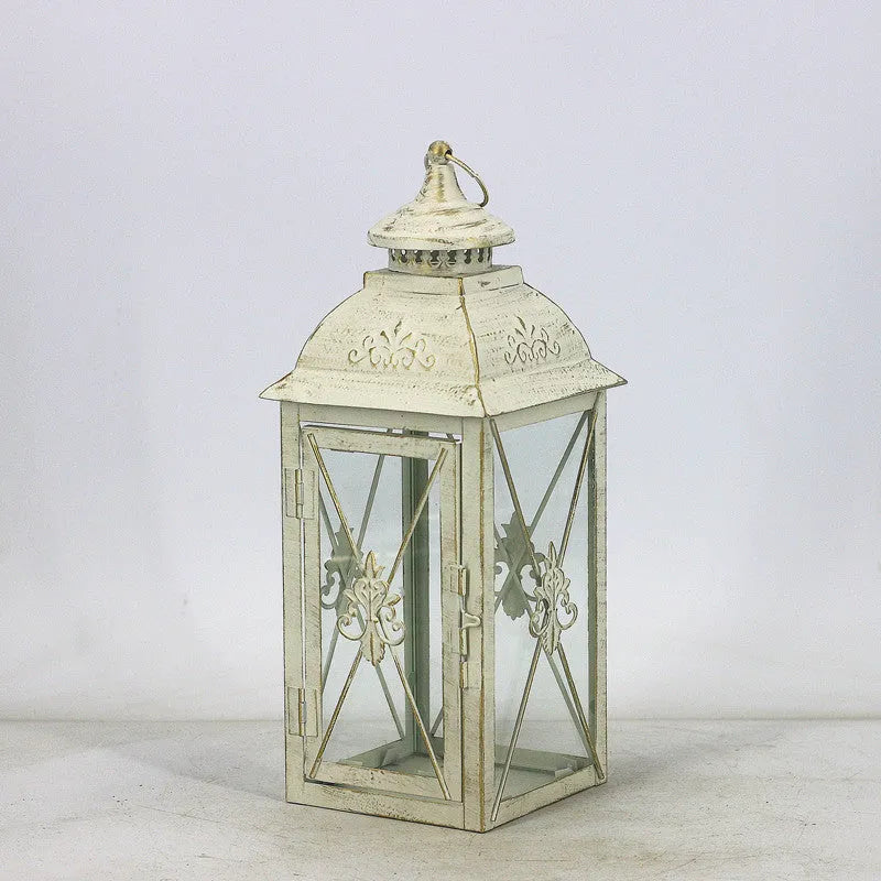 Black wrought iron floor-standing storm lantern with tempered glass panels for outdoor candle lighting
