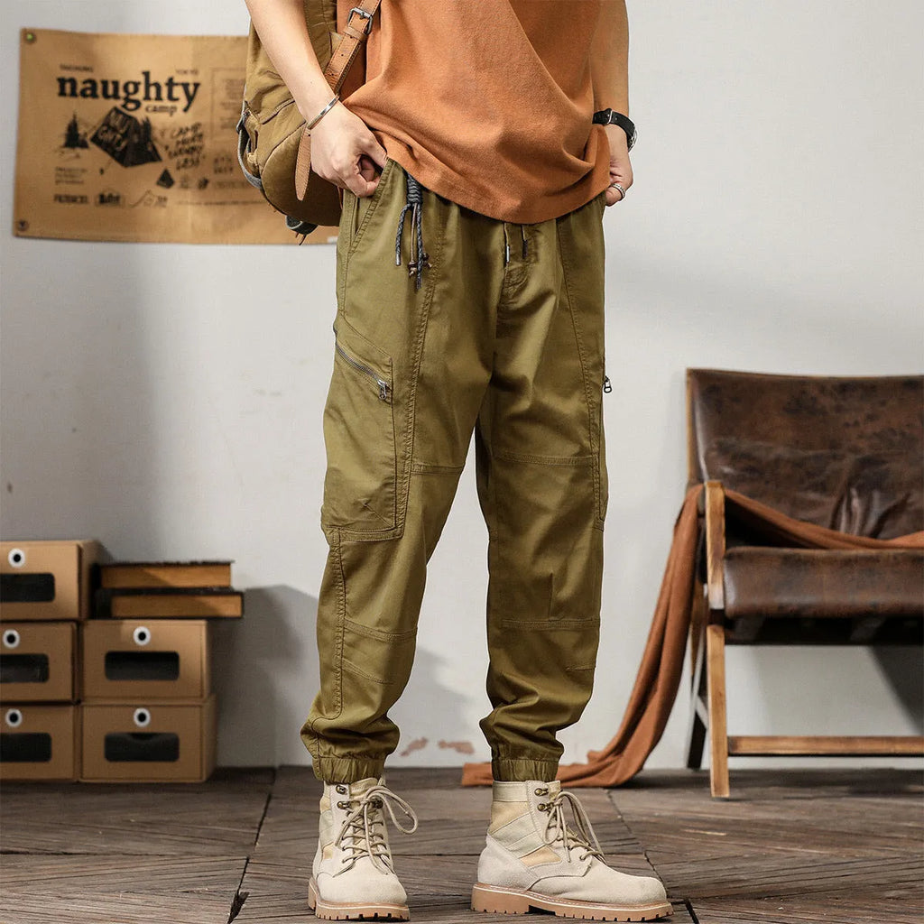 Men's khaki cotton tapered harem pants with an ankle band and loose fit.