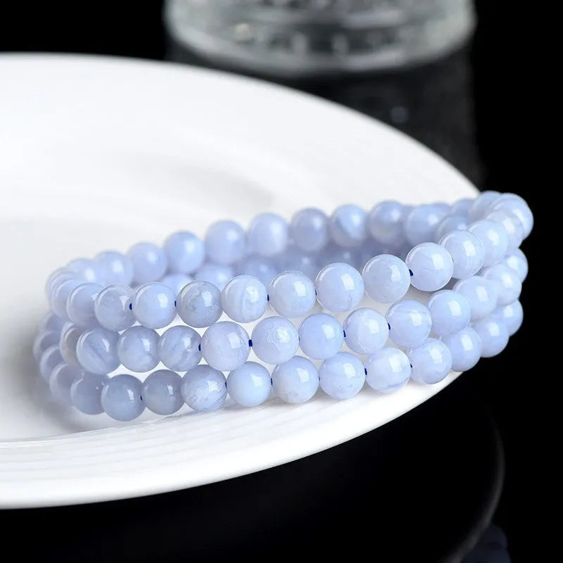 Blue agate bracelet with natural striped pattern and scattered bead design featuring Ruyi elements