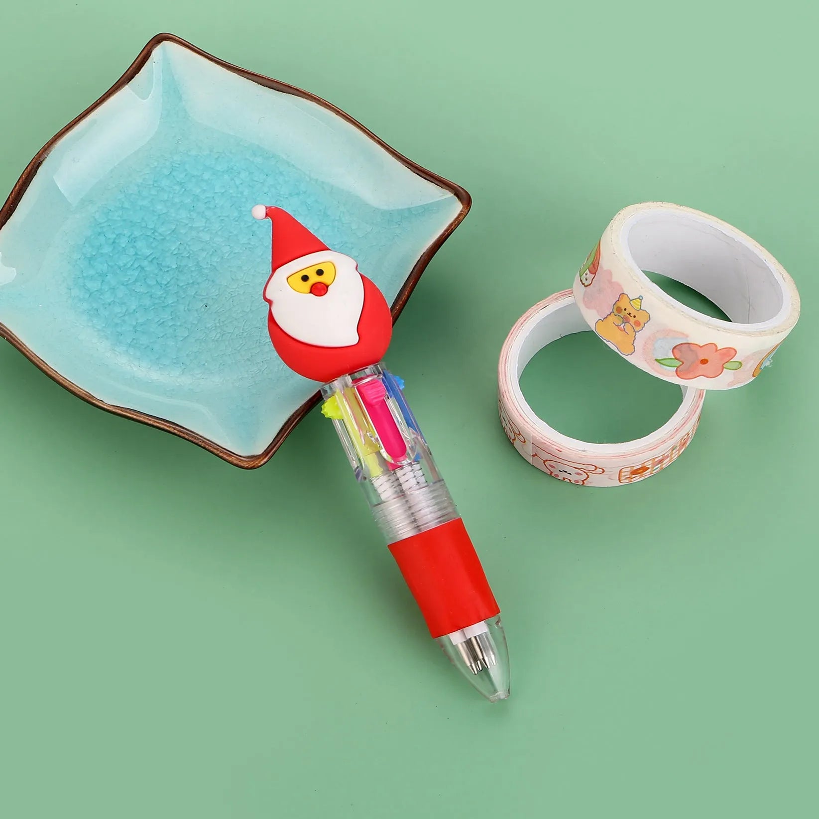 Christmas-themed ballpoint pen with press button, showing designs of snowmen, reindeer, and trees on plastic barrel.
