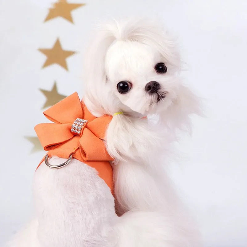 A pink microfiber dog chest strap with a large decorative bowknot, shown alongside blue and orange colour options.