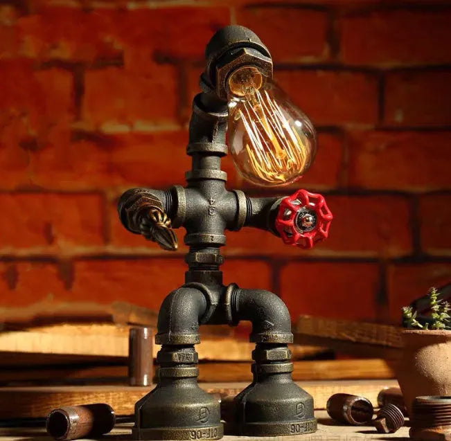 Green bronze vintage robot table lamp with industrial iron pipe design on wooden desk