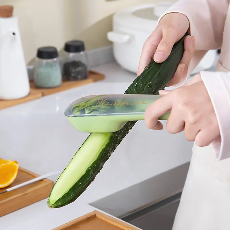 Green fruit and vegetable peeler with a storage tube and stainless steel blade.