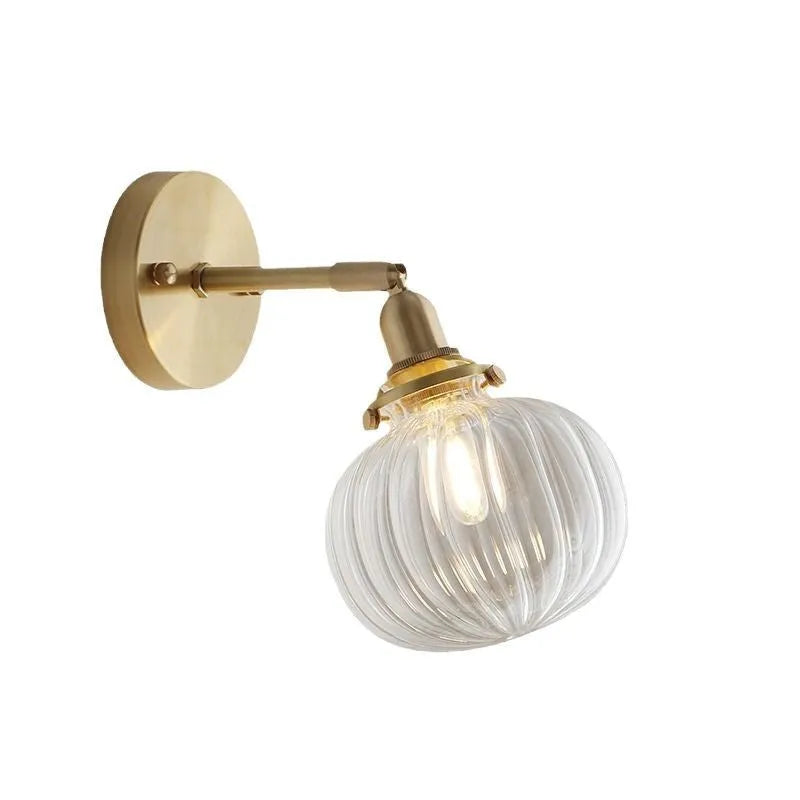 Pumpkin-shaped transparent glass wall lamp mounted on a wall
