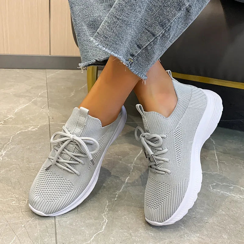 Women's creamy white Flyknit running shoes with mesh lining and low-top design on a rubber sole