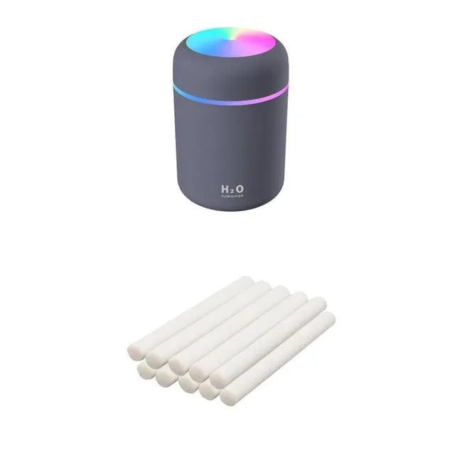 Pink USB mini humidifier with LED lights and water tank on desk