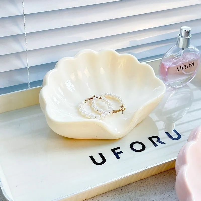 White or pink shell-shaped plastic soap dish for bathroom countertop.