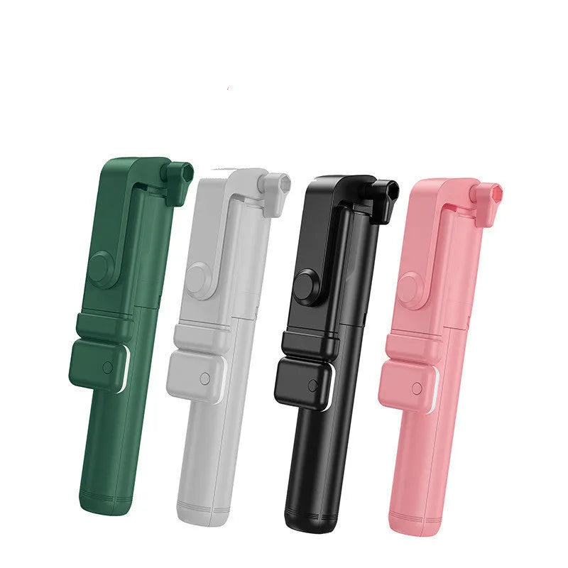 Black Bluetooth selfie stick tripod with phone holder, fill light, and remote control on a table.