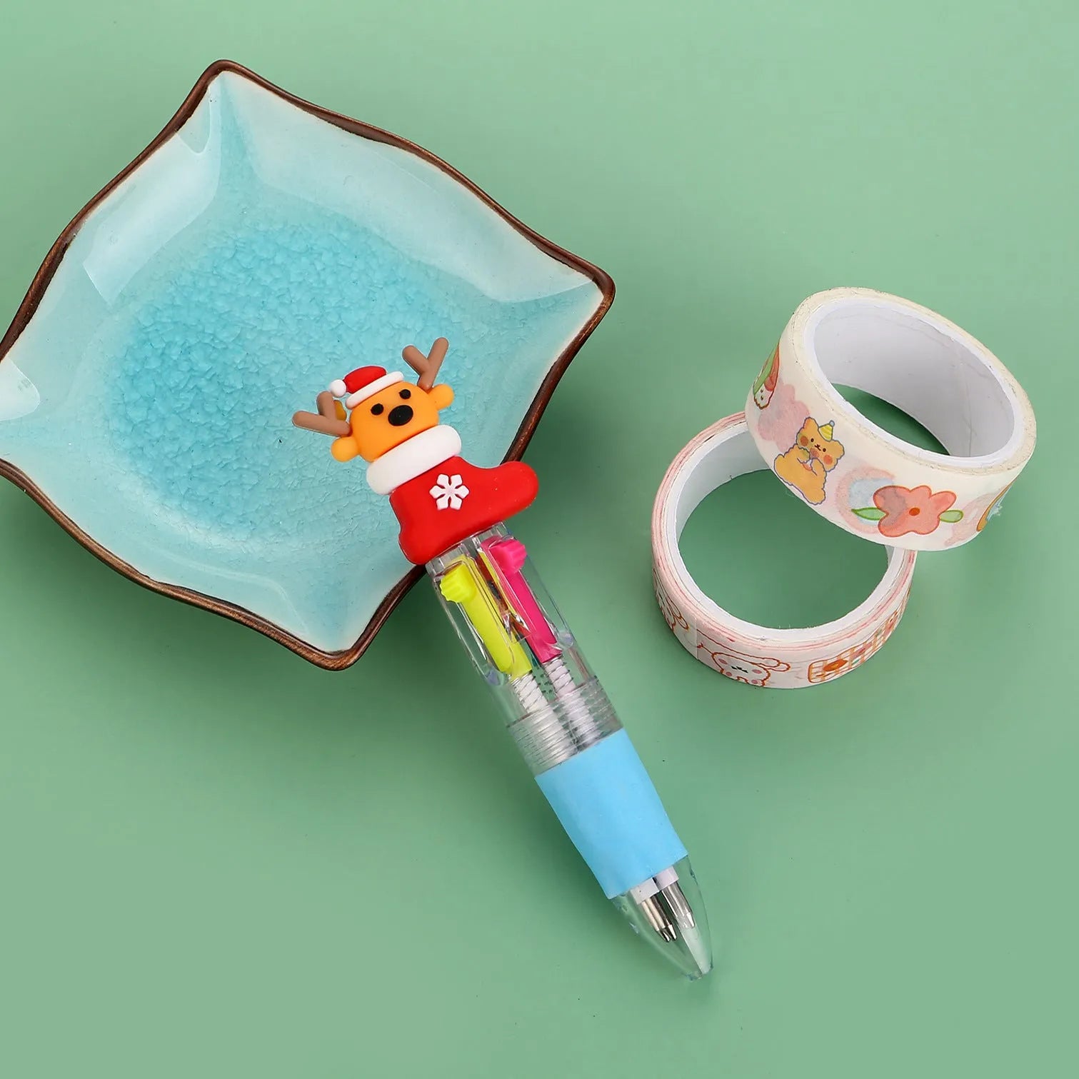 Christmas-themed ballpoint pen with press button, showing designs of snowmen, reindeer, and trees on plastic barrel.