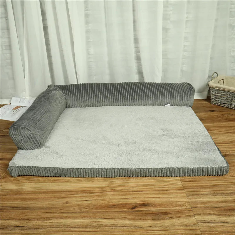 Corduroy dog sofa bed in grey, showing high sides and non-slip base, placed on a wooden floor.