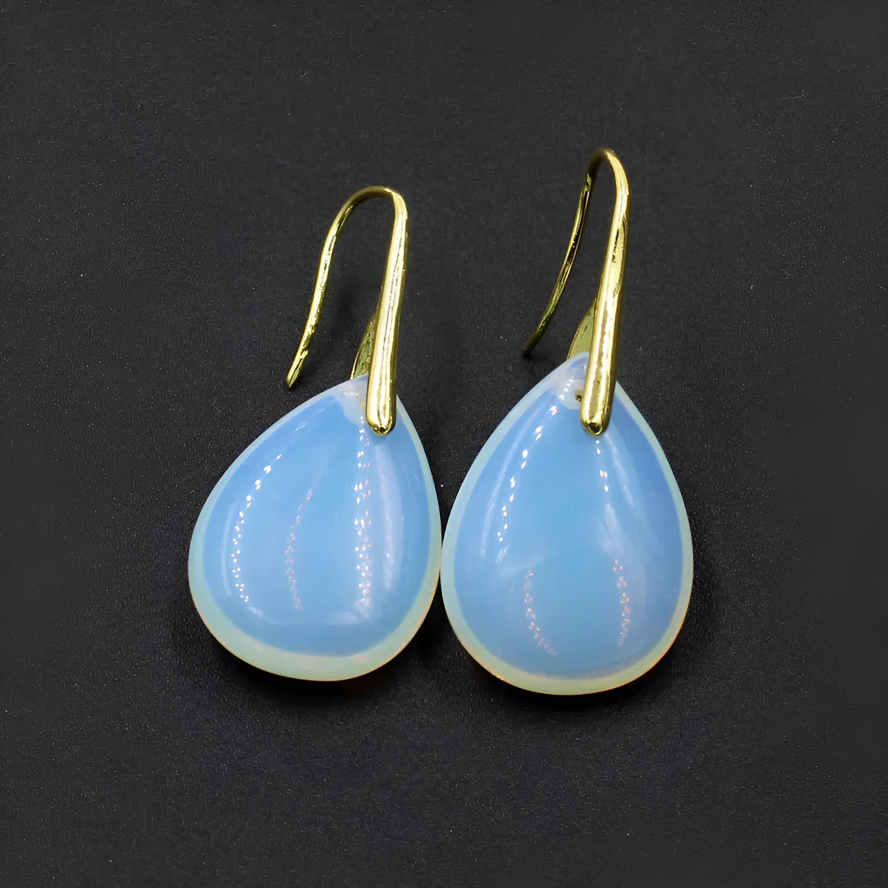 A pair of geometric water drop earrings made from crystal in one of nine colours, with an electroplated metal setting.