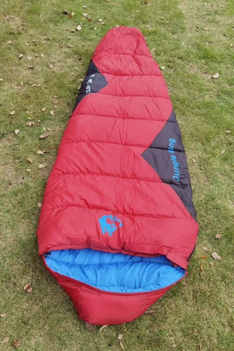 Outdoor cotton sleeping bag in Army Green with its compression storage sack laid beside it.