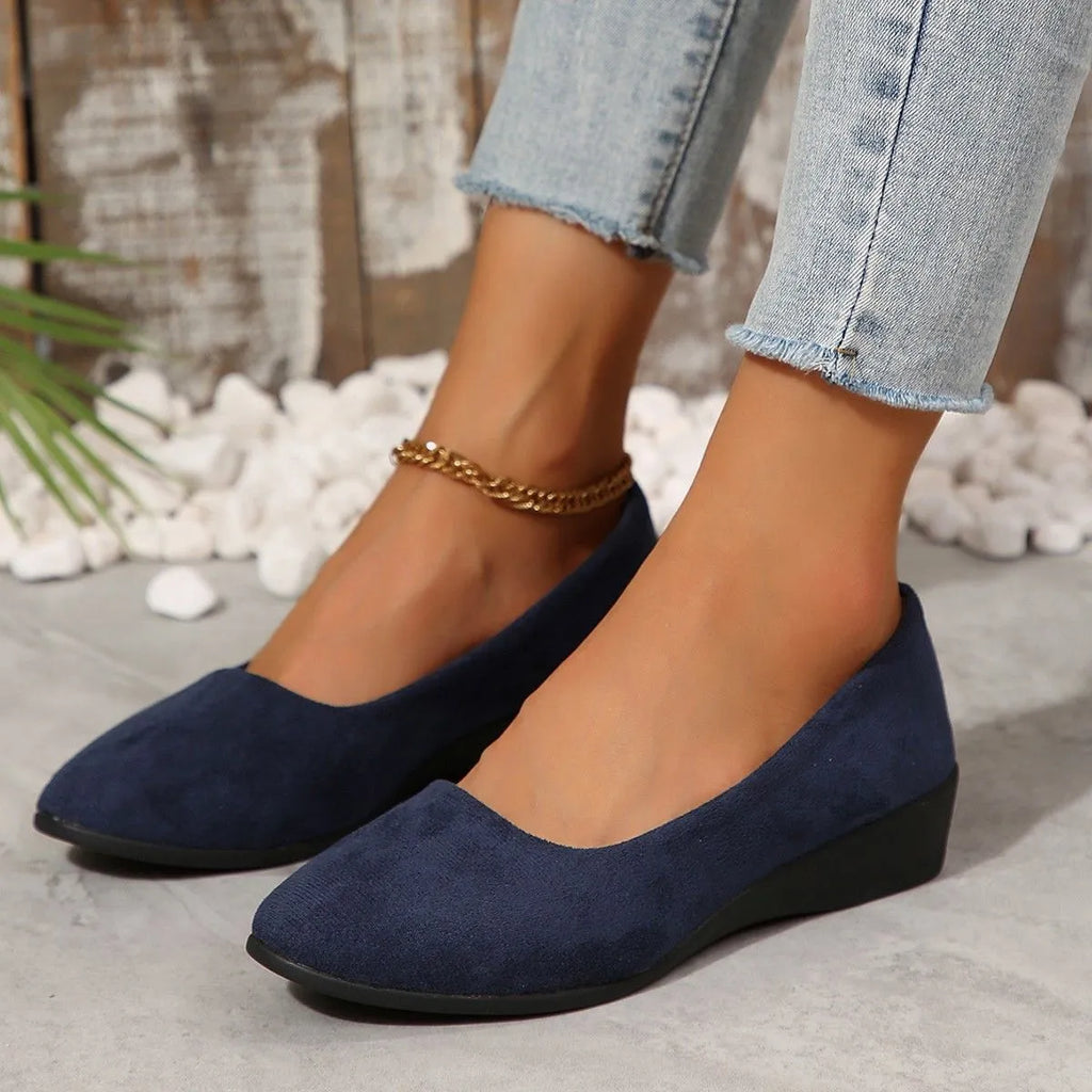 Women's pointed toe suede wedge pumps in light brown with a shallow mouth cut and low rubber sole.