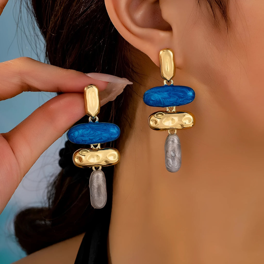 A pair of simple geometric stud earrings with a multicolour metallic finish.