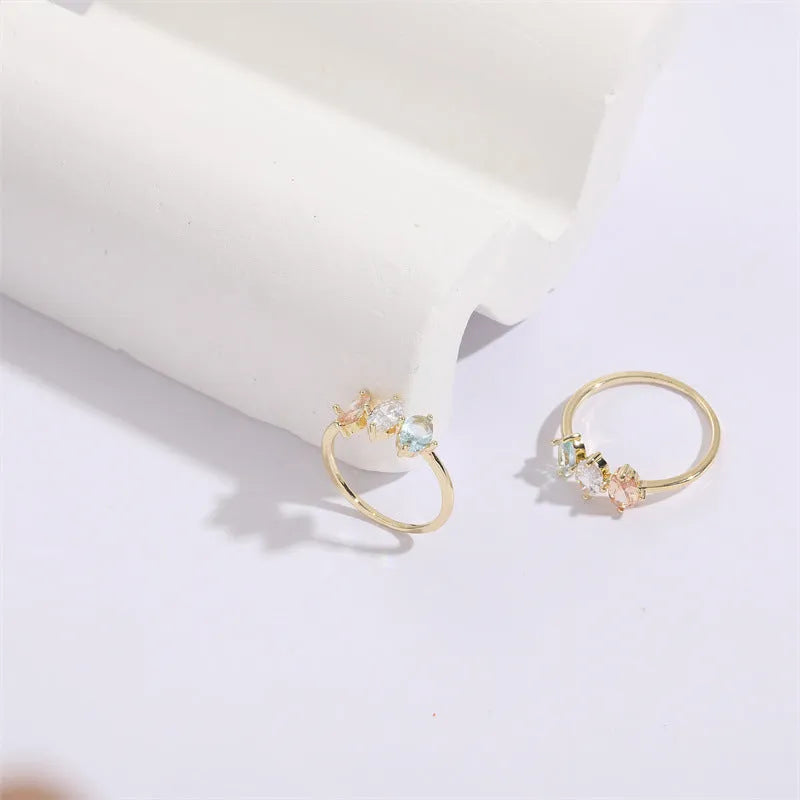 Geometric triangle women's ring with tricolor zircon horse eye design in electroplated gold.