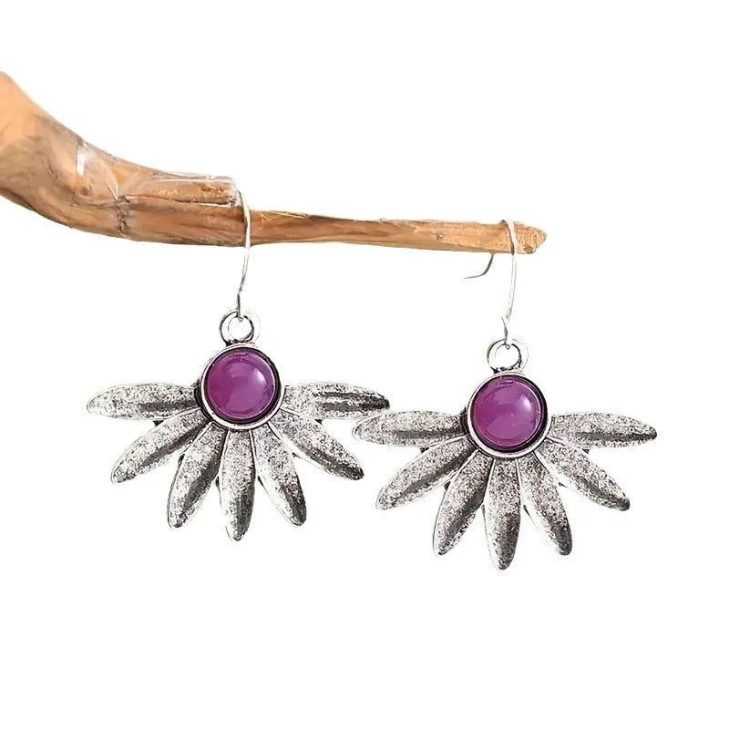 Close-up of purple Bohemian style flower earrings with resin gemstones and Zodiac animal detailing on alloy.